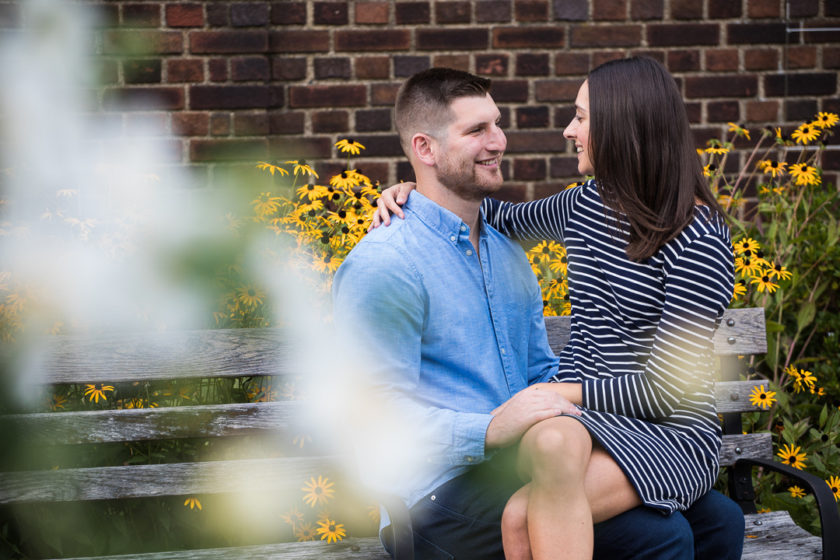 Bride to be sits on groom to be's lap