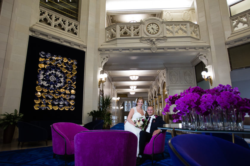 Bride and Groom in lobby of Pittsburgh Union Trust Building with purple chairs