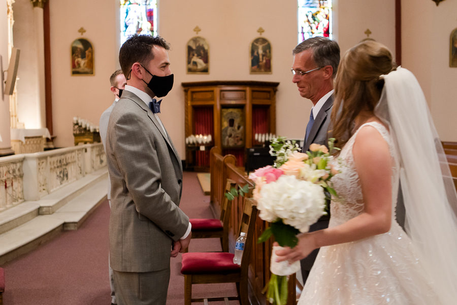 Masked groom greeting his bride